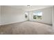 Spacious bedroom with natural light, neutral carpet, and view of the outdoors at 634 Conover Rd, Durham, NC 27703