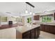 Bright kitchen with an island, dark cabinetry, and adjacent living room with a fireplace at 634 Conover Rd, Durham, NC 27703