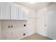 Functional laundry room with white cabinets and tile flooring, ready for appliances at 634 Conover Rd, Durham, NC 27703
