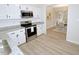 Bright kitchen featuring white cabinets, granite countertops, stainless steel appliances, and wood-look flooring at 6525 New Market Way, Raleigh, NC 27615
