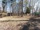 Expansive backyard with mature trees, with a deck and a small wooden shed at 7704 Cresthill Ct, Raleigh, NC 27615