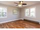 Bright and airy bedroom featuring hardwood floors, neutral walls, and plenty of natural light from the windows at 7704 Cresthill Ct, Raleigh, NC 27615