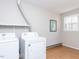 Functional laundry room with washer, dryer, and a window, providing a convenient space for laundry tasks at 7704 Cresthill Ct, Raleigh, NC 27615