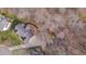 Aerial view shows home with large deck, patio with fire pit and hot tub, long driveway and mature trees at 8015 Papaya Dr, Raleigh, NC 27613