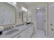 Bright bathroom with double sinks, granite countertop, and pristine white cabinetry at 8015 Papaya Dr, Raleigh, NC 27613