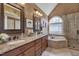 Bathroom with double vanity, granite countertops, soaking tub, and walk-in shower at 8015 Papaya Dr, Raleigh, NC 27613