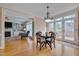 Bright dining area with wooden table and chairs near a large window and an open view to the living room at 8015 Papaya Dr, Raleigh, NC 27613