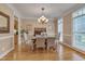 Formal dining room with hardwood floors, elegant chandelier, and sophisticated decor at 8015 Papaya Dr, Raleigh, NC 27613