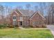 Beautiful brick home boasts a manicured lawn, mature trees and a welcoming front entrance at 8015 Papaya Dr, Raleigh, NC 27613