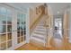 Inviting foyer features hardwood floors, a staircase, and glass french doors to an office space at 8015 Papaya Dr, Raleigh, NC 27613