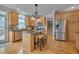Bright kitchen features wooden cabinets, stainless steel appliances, granite countertops, and an island with stool seating at 8015 Papaya Dr, Raleigh, NC 27613