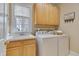 Functional laundry room with wooden cabinets, sink, and modern washer and dryer at 8015 Papaya Dr, Raleigh, NC 27613