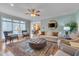 Well-lit living room with stylish furniture, a fireplace, and a view into the adjacent kitchen and dining area at 8015 Papaya Dr, Raleigh, NC 27613