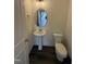 Cozy powder room features a pedestal sink, modern fixtures, and stylish dark hardwood floors at 81 Reece Dr, Sanford, NC 27332