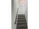 Carpeted stairway with wooden handrail offers an elegant transition between floors at 81 Reece Dr, Sanford, NC 27332