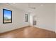 Bright bedroom with hardwood floors, two windows, and a view of the en-suite bathroom at 838 Woodburn Rd, Raleigh, NC 27605