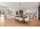Elegant dining area with a wooden table and seating, open to the kitchen and stairway at 838 Woodburn Rd, Raleigh, NC 27605