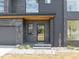 Close-up of a modern home's entrance with a gray brick facade and well-manicured front yard at 838 Woodburn Rd, Raleigh, NC 27605