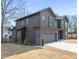 Side view of a modern two-story gray home with an attached garage and well-maintained lawn at 838 Woodburn Rd, Raleigh, NC 27605