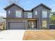 Modern two-story home featuring a gray brick and siding exterior, large windows, and attached garage at 838 Woodburn Rd, Raleigh, NC 27605
