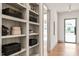 Hallway with light hardwood floors, white walls, a view of the front door, and built-in shelving at 838 Woodburn Rd, Raleigh, NC 27605