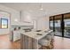 Modern kitchen with a center island, bar seating, and natural light from large windows at 838 Woodburn Rd, Raleigh, NC 27605
