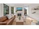 Bright living room with large windows, a fireplace, modern furniture, and hardwood floors at 838 Woodburn Rd, Raleigh, NC 27605