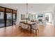 Bright dining area connected to the living room with large windows and wood floors at 838 Woodburn Rd, Raleigh, NC 27605