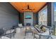 Covered patio featuring a brick fireplace, comfortable seating, and a stylish ceiling fan at 838 Woodburn Rd, Raleigh, NC 27605