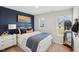Cozy bedroom with an accent wall, plush bedding, and ample natural light from large windows at 917 Montague Ave, Durham, NC 27703