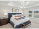 This spacious main bedroom features a tray ceiling and a large window overlooking greenery at 917 Montague Ave, Durham, NC 27703