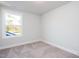 A well-lit bedroom with neutral carpet and trim, featuring a large window for natural light at 928 Allen Park Dr, Knightdale, NC 27604