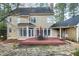 Backyard view features a deck with outdoor seating, mature trees, and landscaping at 100 Burlingame Way, Cary, NC 27513