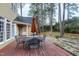 Backyard view features a deck with outdoor seating, mature trees, and landscaping at 100 Burlingame Way, Cary, NC 27513