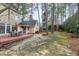 Backyard view features a deck with outdoor seating, mature trees, and landscaping at 100 Burlingame Way, Cary, NC 27513