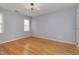 This bedroom has hardwood flooring, two windows and a unique, modern ceiling light at 100 Burlingame Way, Cary, NC 27513