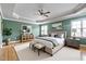Staged bedroom with a ceiling fan, hardwood floors, and large windows at 100 Burlingame Way, Cary, NC 27513