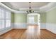 Bright dining room featuring hardwood floors, large windows, and decorative chandelier at 100 Burlingame Way, Cary, NC 27513