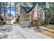 Charming two-story home featuring stone accents, attached garages, mature trees, and a concrete driveway at 100 Burlingame Way, Cary, NC 27513