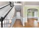 Inviting foyer with hardwood floors, elegant staircase, wainscoting, and an arched doorway at 100 Burlingame Way, Cary, NC 27513