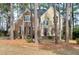 Charming two-story home with stone and siding exterior, surrounded by mature trees at 100 Burlingame Way, Cary, NC 27513