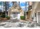 Detached garage featuring white door, stone trim, lamp, manicured bushes, and concrete driveway at 100 Burlingame Way, Cary, NC 27513