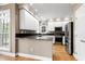 Modern kitchen with white cabinets, stainless steel appliances, and a breakfast bar at 100 Burlingame Way, Cary, NC 27513