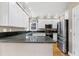 Well-lit kitchen featuring white cabinets, granite countertops, and stainless steel appliances at 100 Burlingame Way, Cary, NC 27513