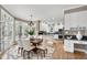 Bright kitchen and dining area with modern appliances, island, and white cabinetry at 100 Burlingame Way, Cary, NC 27513
