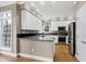 Well-lit kitchen featuring white cabinets, granite countertops, and stainless steel appliances at 100 Burlingame Way, Cary, NC 27513