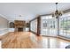 Open living room showcasing a stone fireplace, built-in shelving, and hardwood floors at 100 Burlingame Way, Cary, NC 27513