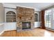 Living room featuring a stone fireplace, built-in shelving, and hardwood floors at 100 Burlingame Way, Cary, NC 27513