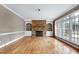 Spacious living room featuring a stone fireplace, built-in shelving, and hardwood floors at 100 Burlingame Way, Cary, NC 27513