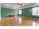 Spacious main bedroom featuring hardwood floors, tray ceiling, and two windows at 100 Burlingame Way, Cary, NC 27513